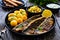 Fried herring fillets with potatoes and vegetable salad on wooden table