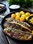 Fried herring fillets with potatoes and vegetable salad on wooden table