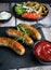 Fried homemade sausages on a wooden background. With sauces. lunch