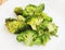 Fried inflorescences of broccoli with provencal herbs on white plate