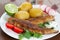 Fried mackerel with potato boiled with skin on and vegetables and lime on garnish with white sauce