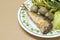 Fried mackerel with shrimp paste sauce in dish on cardboard back