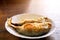 Fried mackerels on white ceramic plate and wooden table with natural sun light background.