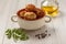 Fried meat cutlets in ceramic soup bowl, glass bottle with sunflower oil, branch of fresh parsley and black peppercorn