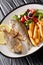 Fried Mediterranean Sarpa salpa fish served with fresh salad and french fries close-up on a plate. vertical
