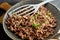 Fried minced meat on pan with green chives