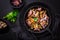 Fried mushrooms with red onions and herbs on dark background