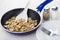 Fried mushrooms, spoon in frying pan, plate, fork, salt, pepper