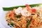 Fried noodle Thai style with prawns, Stir fry noodles with shrimp in padthai style on table. Front view isolate white , brown ba