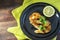 Fried northern pike steaks with lemon and parsley garnish, black