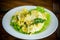 Fried omelet with thin vermicelli with salad leaves in a plate