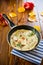 Fried omelets with various autumn vegetables in a frying pan on a wooden table.