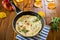 Fried omelets with various autumn vegetables in a frying pan on a wooden table.