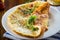 Fried omelettes with various autumn vegetables in a plate on a wooden table.