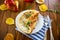 Fried omelettes with various autumn vegetables in a plate on a wooden table.