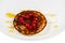 Fried pancakes with cranberry heart shaped with honey on a plate