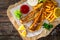 Fried perch with French fries and lemon served on paper on wooden table