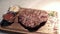 Fried piece of meat served on wooden tray. Action. Close-up of juicy piece of steak cooked by professional chef and