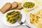 Fried pieces of potato, bread, gherkins, green peas, fork