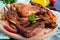 Fried pieces of rabbit with vegetables on a wooden tray