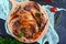 Fried pieces of rabbit with vegetables on a wooden tray on a dark background