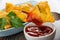 Fried pies samsa, parsley in oval plate, samsa on fork above bowl with ketchup on wooden table