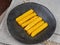 Fried polenta fingers set on a dark brown plate