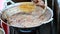 Fried pork in the boiling pan in the outdoor market of Thailand