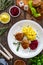 Fried pork meatballs with mashed potatoes and grated beets on wooden table