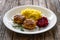 Fried pork meatballs with mashed potatoes and grated beets on wooden table