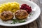 Fried pork meatballs with mashed potatoes and grated beets on wooden table