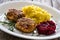 Fried pork meatballs with mashed potatoes and grated beets on wooden table