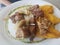 Fried pork with plantains on white plate in Puerto Rico