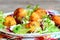 Fried potato balls with salad leaf mix and basil on a plate. Small golden fried balls made from mashed potatoes