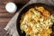 Fried potato in pan on dark wooden background. Belarusian and Russian cuisine.