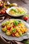 Fried potato salad with lettuce, pepper, onion and baked fish fillets covered with cheese