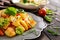 Fried potato salad with lettuce, pepper, onion and baked fish fillets covered with cheese