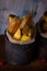 Fried potato stripps on wooden board in old worn cans