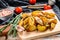 Fried potato wedges, French fries on a wooden cutting board. White background. Top view