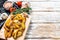 Fried potato wedges, French fries on a wooden cutting board. White background. Top view. Copy space