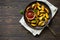 Fried potatoes and bowl of tomato sauce on a dark clay plate