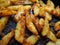 Fried potatoes or French fries with turmeric, curry and bread crumbs. Close-up. Delicious side dish. Bakery potatoes. Latin