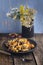 Fried potatoes with mushrooms in a dark ceramic dish with an old wooden table