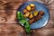 Fried potatoes in a uniform and meat cutlets in a plate with greens