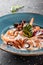 Fried prawns, mussels, calamari, cuttlefish, octopus with cream sauce in plate on dark stone background. Clean eating, healthy