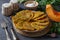 Fried pumpkin pancakes with garlic, served for breakfast with sour cream on gray table