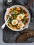 Fried quail eggs and vegetables - healthy breakfast or snack. On a wooden table