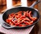 Fried red bell peppers cooling in iron skillet