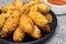 Fried rice balls called bolinho de arroz in a black plate in rustic background close