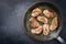 Fried saddle of pork steak with herbs in a rustic frying pan